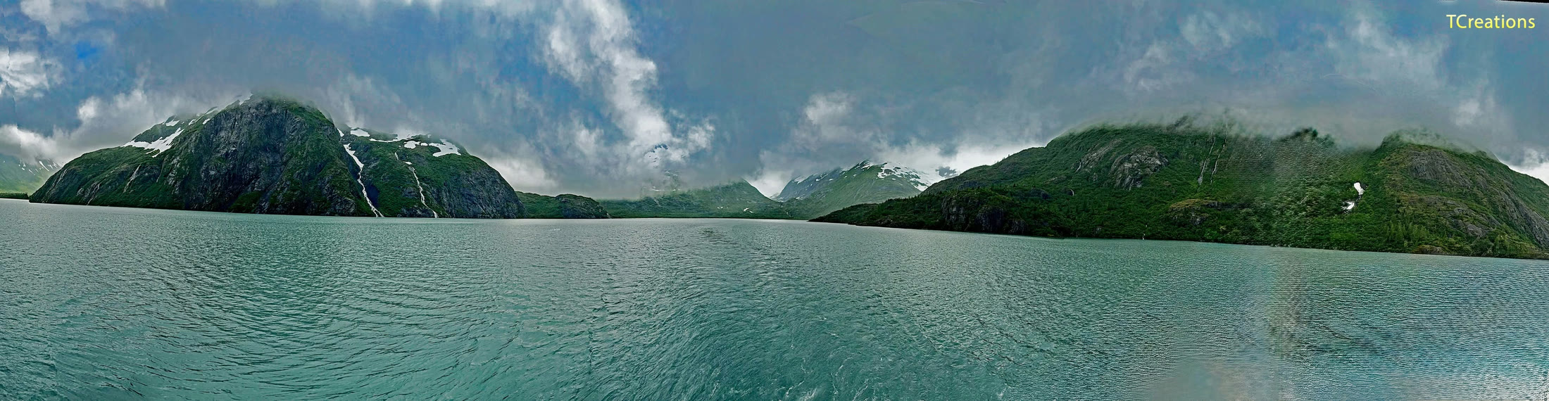 A turquoise fjord between green cliffs